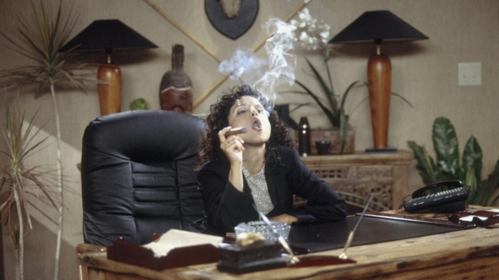 Julia Louis-Dreyfus smoking a cigar as Elaine Benes in Seinfeld