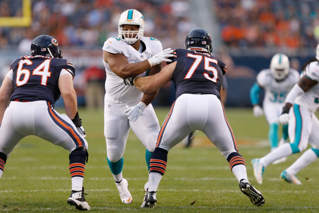 Miami Dolphins defensive tackle Ndamukong Suh (93) runs in pursuit as he is blocked by Chicago Bears guard Kyle Long (75) and center Will Montgomery (64) during a week 1 NFL preseason football game in Chicago, Illinois on Thursday, August 13, 2015. The Bears defeated the Dolphins 27-10. (AP Photo/Scott Boehm)