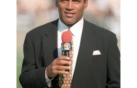 OJ Simpson serves as a NBC Sports sideline reporter for AFC Wild Card playoff game between the Denver Broncos and Oakland Raiders at the Los Angeles Memorial Coliseum on Jan. 9, 1994.