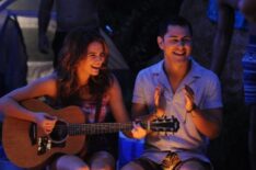 Faking It - Katie Stevens playing guitar around a campfire