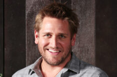 Chef Curtis Stone holds a wooden box filled with winter vegetables and kalettes during a photo shoot in Sydney