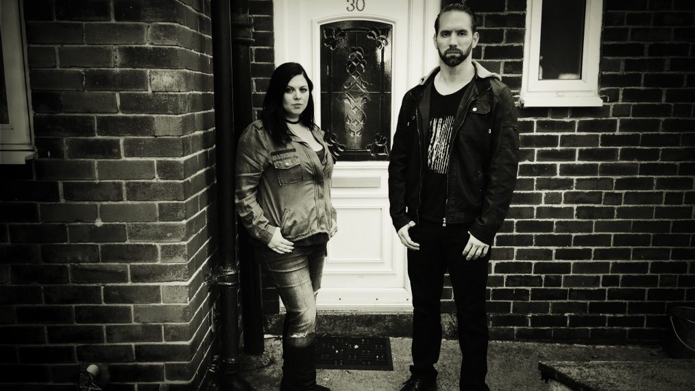 Katrina Weidman and Nick Groff stand in front of door of Black Monk House