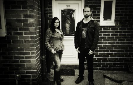 Katrina Weidman and Nick Groff stand in front of door of Black Monk House