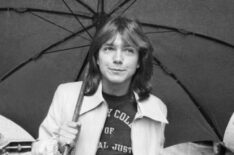 David Cassidy walking down a road in Paris with an umbrella in April 1974