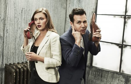 Tracy Spiridakos and Jon Seda talking into their shoe phones in the NBCUniversal Portrait Studio, August 2017