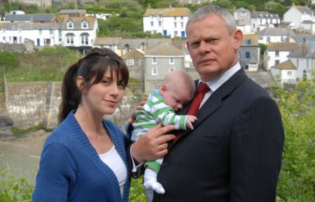 Caroline Catz as Louisa Glasson and Martin Clunes as Dr. Martin Ellingham holding a baby in Doc Martin