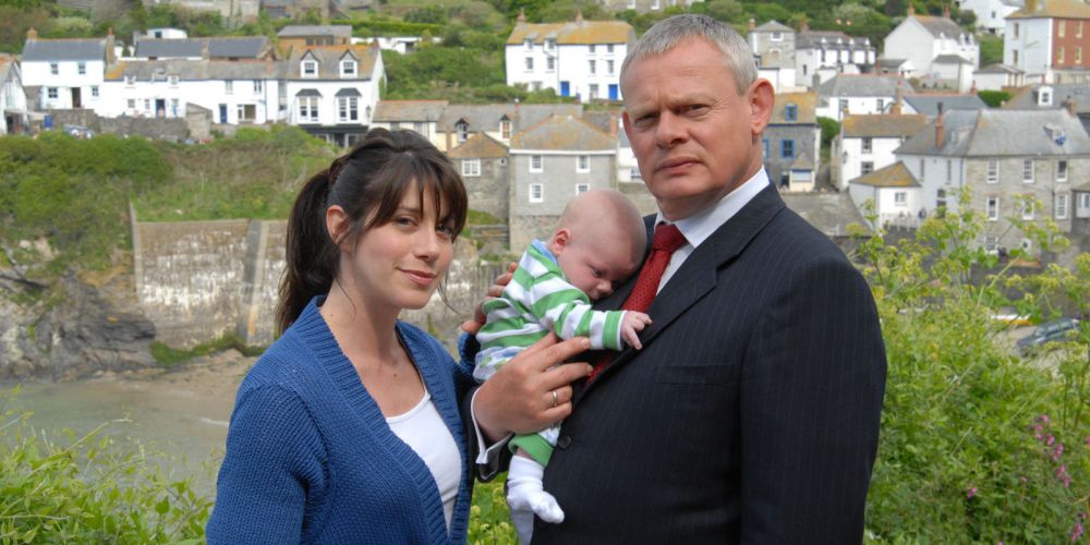 Caroline Catz as Louisa Glasson and Martin Clunes as Dr. Martin Ellingham holding a baby in Doc Martin