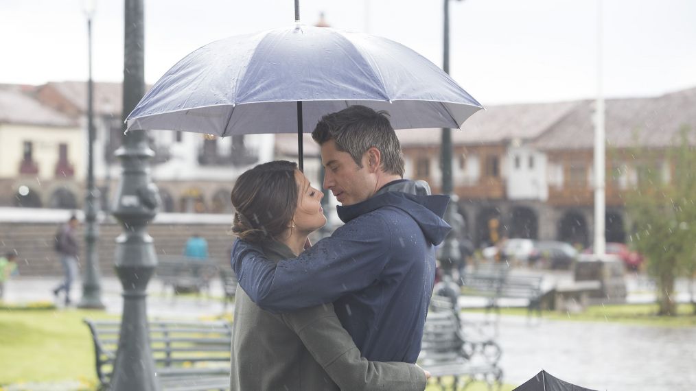 Becca Kufrin and Arie Luyendyk Jr. in the rain with an umbrella