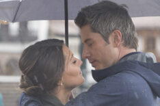 Becca Kufrin and Arie Luyendyk Jr. in the rain with an umbrella