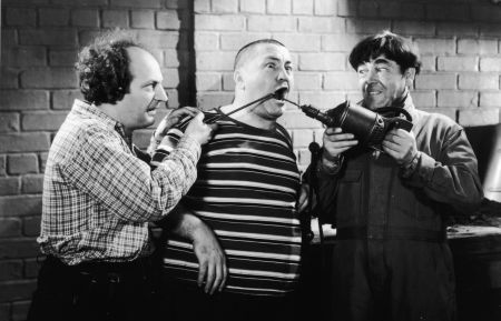 Larry Fine and Moe Howard abuse Curly Howard with tools in a still from the Three Stooges