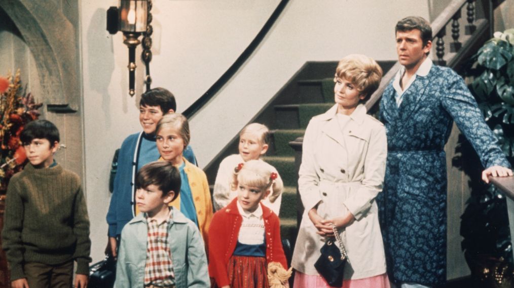American actors Robert Reed and Florence Henderson stand in a hotel lobby with their television family in a still from the TV series 'The Brady Bunch,' circa 1969. (L-R) Christopher Knight, Barry Williams, Mike Lookinland, Maureen McCormick, Eve Plumb, Susan Olsen, Henderson, Reed, unidentified. (Photo by Paramount Television/Courtesy of Getty Images)