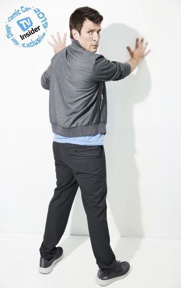 Nathan Fillion with hands against the wall