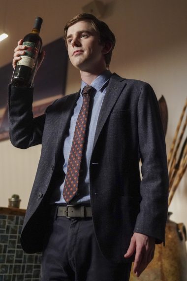 Freddie Highmore as Dr. Shaun Murphy holds up a wine bottle in The Good Doctor