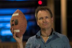 Phil Keoghan holding a football on the season finale of Phil Keoghan