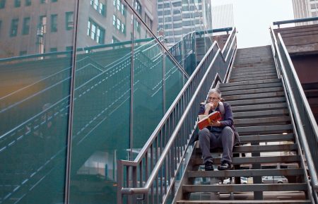 Abby McEnany reading on the steps in Work in Progress