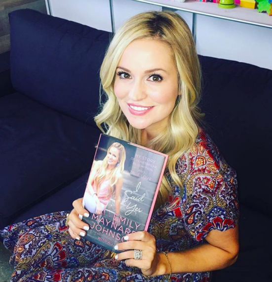 Emily Maynard of The Bachelorette holds up her book