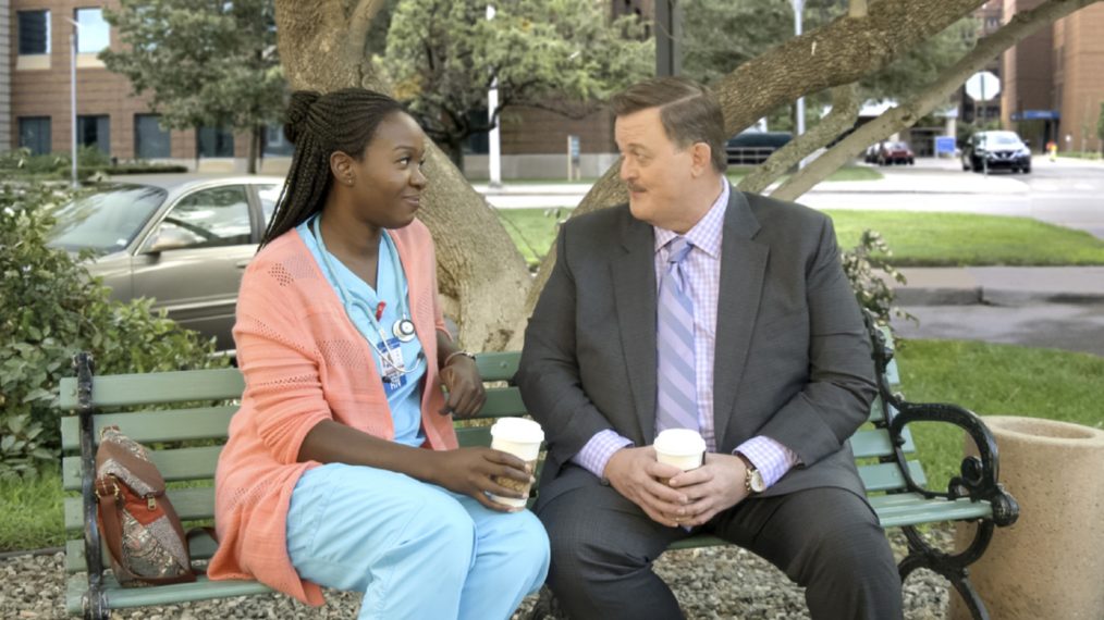 Folake Olowofoyeku and Billy Gardell sitting on a park bench in Bob Hearts Abishola