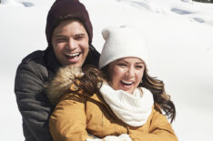 Jeremy Jordan and Janel Parrish riding a sled in Holly and Ivy