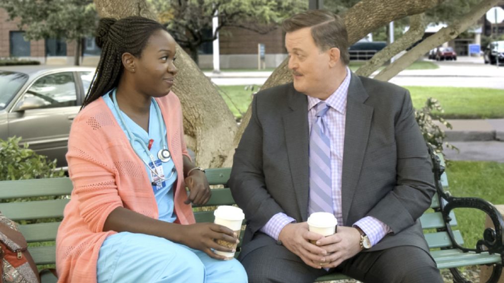 Folake Olowofoyeku and Billy Gardell sitting on a park bench in Bob Hearts Abishola