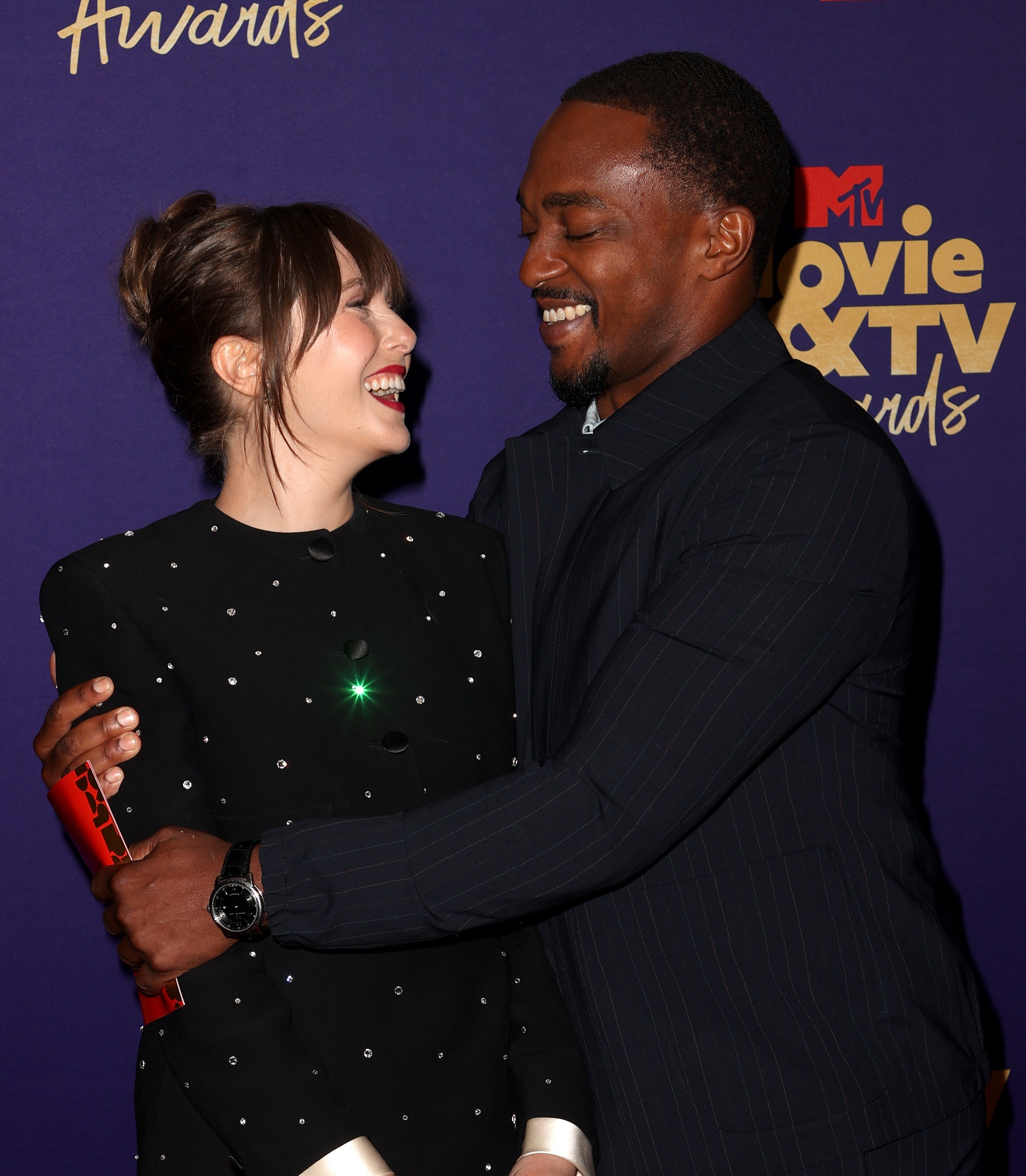 Elizabeth Olsen and Anthony Mackie pose backstage during the 2021 MTV Movie & TV Awards