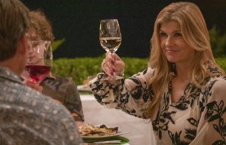 Connie Britton holding up a glass of white wine in The White Lotus