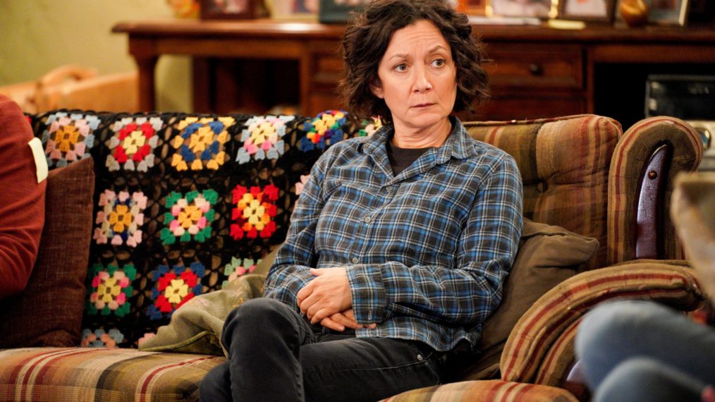 Sara Gilbert sitting on the couch in The Conners