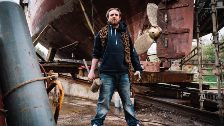 Jake Anderson standing with chains and hammer in Deadliest Catch: The Viking Returns