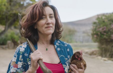 Maria Doyle Kennedy with a rooster and axe in Recipes for Love and Murder