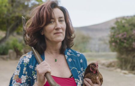 Maria Doyle Kennedy with a rooster and axe in Recipes for Love and Murder