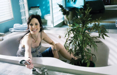 Mary-Louise Parker as Nancy Botwin in a bathtub with a marijuana plant in Weeds