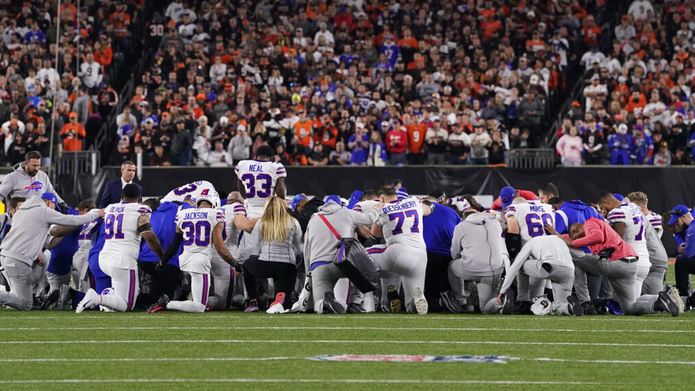 Buffalo Bills players huddle and pray after teammate Damar Hamlin