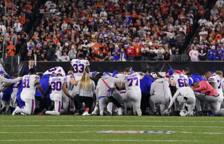 Buffalo Bills players huddle and pray after teammate Damar Hamlin