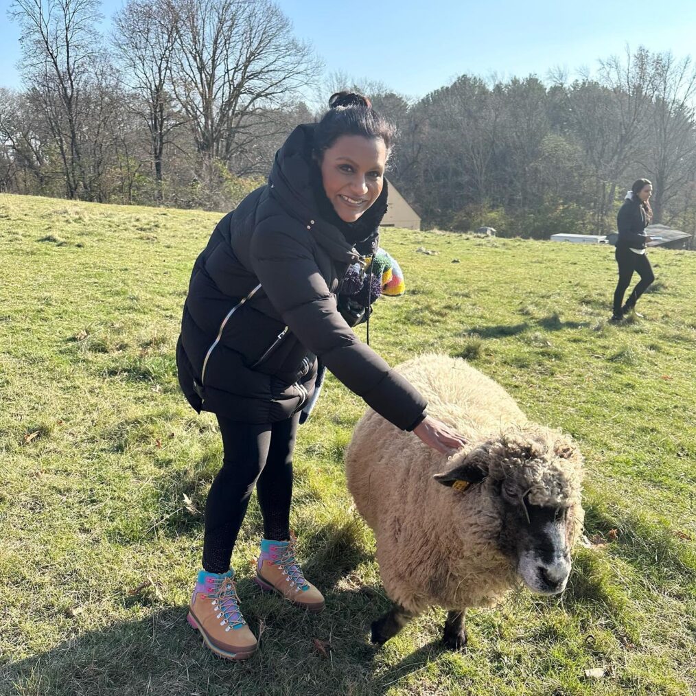 Mindy Kaling pets a sheep