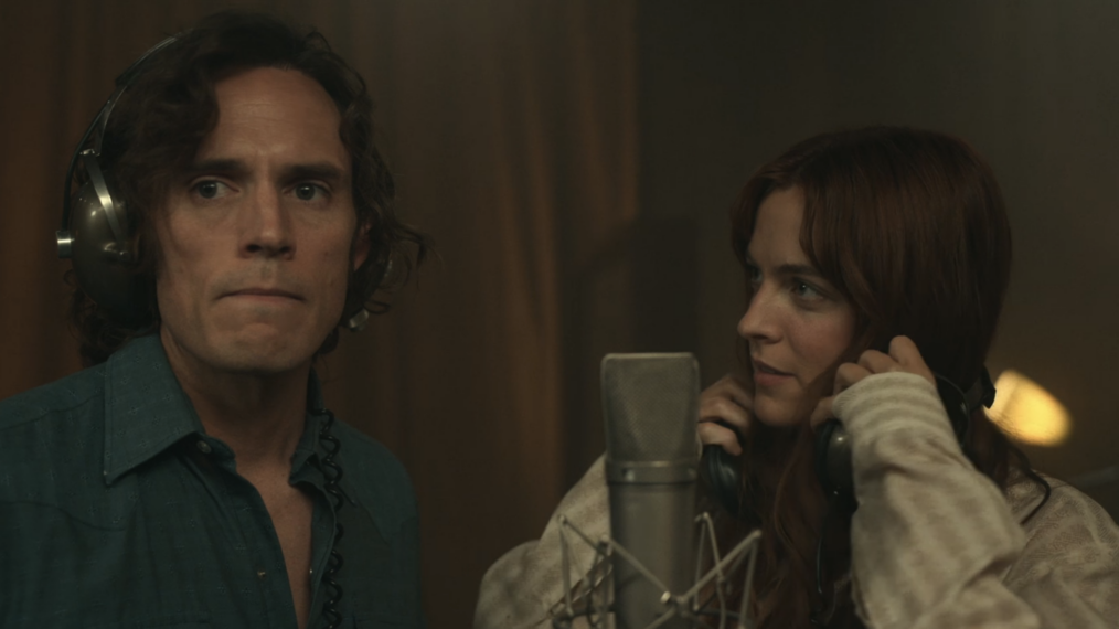 Riley Keough and Sam Claflin in front of a microphone