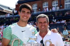 Carlos Alcaraz of Spain poses with the winner's trophy alongside father, Carlos Snr. after victory