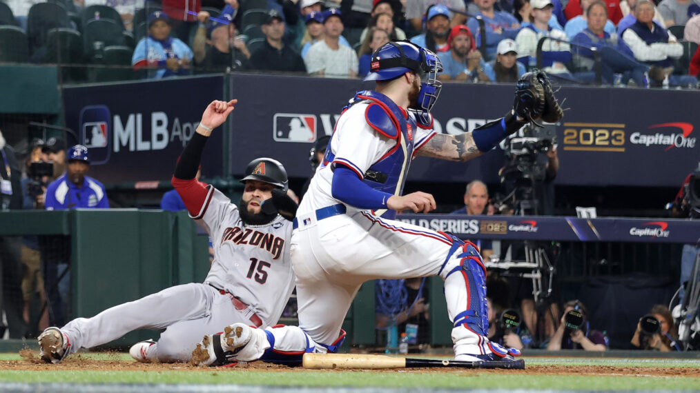 Emmanuel Rivera #15 der Arizona Diamondbacks rutscht in die Home-Plate, um im achten Inning während des zweiten Spiels der World Series im Globe Life Field am 28. Oktober 2023 in Arlington, Texas, einen Lauf an Jonah Heim #28 der Texas Rangers vorbei zu erzielen.