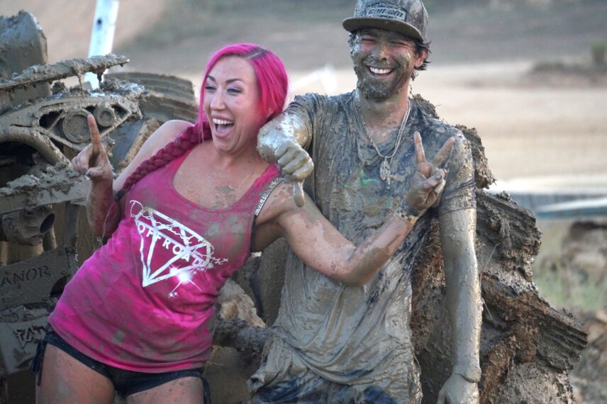 Megan and AJ pose together after a race covered in mud