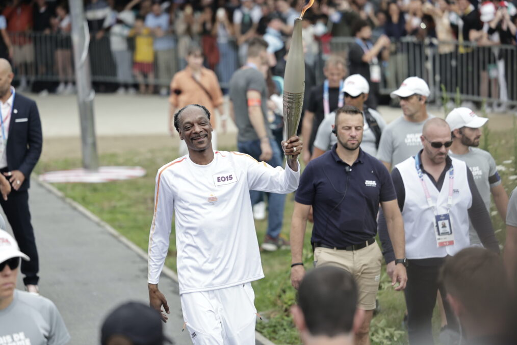 Snoop Dogg holds the torch as part of the 2024 Paris Olympic Games Torch Relay, in Saint-Denis on July 26, 2024 in Paris, France.