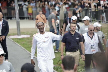 Snoop Dogg holds the torch as part of the 2024 Paris Olympic Games Torch Relay, in Saint-Denis on July 26, 2024 in Paris, France.
