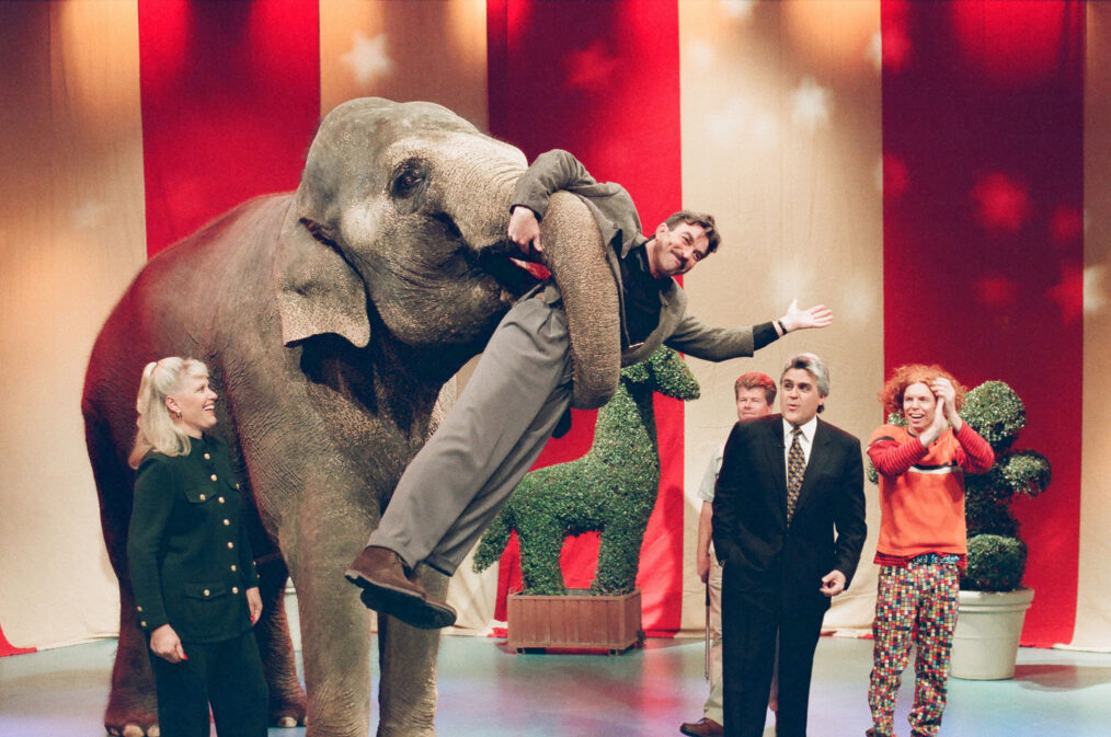 Animal specialist Joan Embery, actor Tom Selleck, host Jay Leno, and comedian Carrot Top with an elephant on The Tonight Show on March 9, 1998