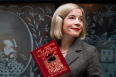 Lucy Worsley holding a copy of The Hound of the Baskervilles in front of The Sherlock Holmes Pub in London__