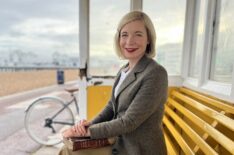 Lucy Worsley in Portsmouth Beach Shelter with book in hand