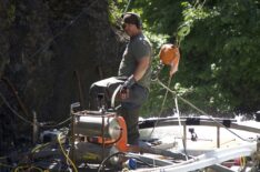 Dustin Hurt standing on the 'Deuce Sluice' overlooking the two divers in the water