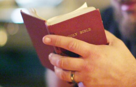 Close up of Tripp Fuller holding a Bible - 'The Road to Edmond'