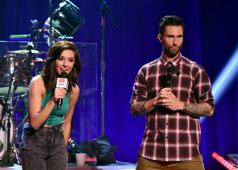 Singers Christina Grimmie (L) and Adam Levine speak onstage druing the iHeartRadio Album Release Party