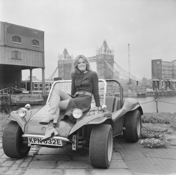 Judy Loe seated on the bonnet of a GP Beach Buggy at St Katharine Docks in London on 9th September 1970.