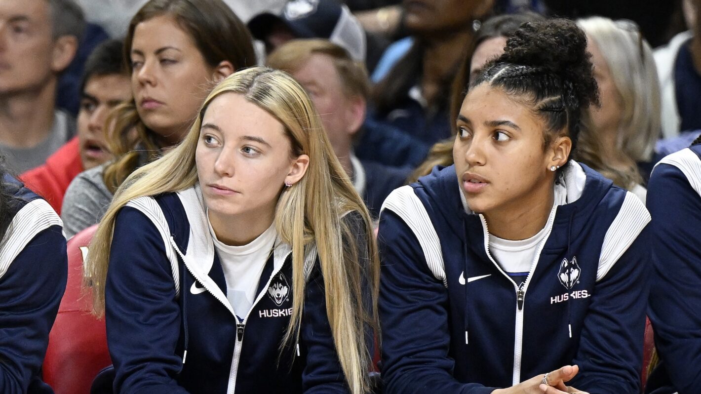 Paige Bueckers #5 and Azzi Fudd #35 of the UConn Huskies watch the game against the Maryland Terrapins in the third quarter at Xfinity Center on December 11, 2022 in College Park, Maryland.