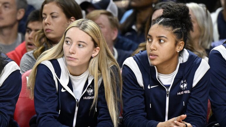 Paige Bueckers #5 and Azzi Fudd #35 of the UConn Huskies watch the game against the Maryland Terrapins in the third quarter at Xfinity Center on December 11, 2022 in College Park, Maryland.