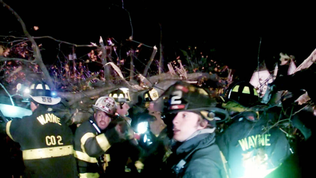 Firefighters work to extract first responders from vehicles pinned beneath fallen trees during Superstorm Sandy in 'Survival Mode' Season 1 Episode 9 on NBC