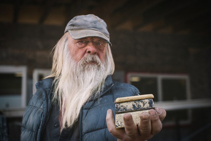 Tony Beets holding 3 gold bars in hand looking down lens, "Gold Rush" Season 16